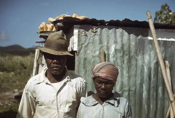 MIGRANT WORKERS, 1941. African American couple standing in front of their run down home