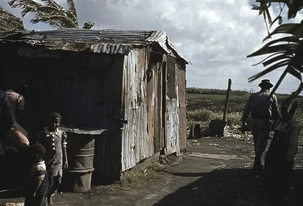 MIGRANT WORKERS, 1941. African American migrant workers near a shack at Belle Glade, Florida