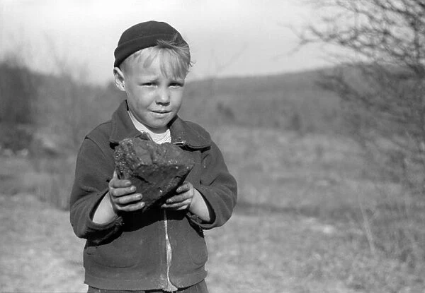 MINER STRIKE, 1939. A miners son holding coal salvaged from a slag pile during