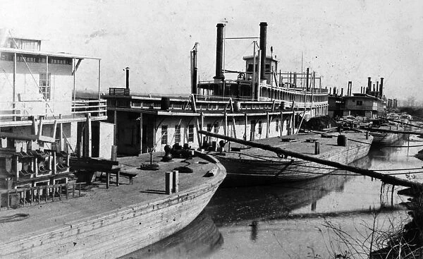 MISSISSIPPI STEAMBOATS. Steamboats and barges moored along the Mississippi River, 1850s