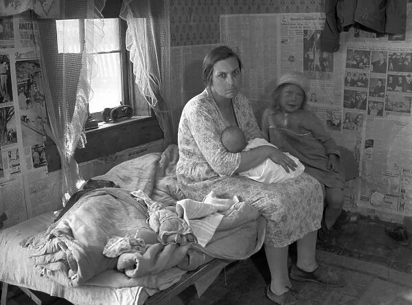 MISSOURI: CABIN, 1936. A mother nursing her baby and seated on a cot beside her