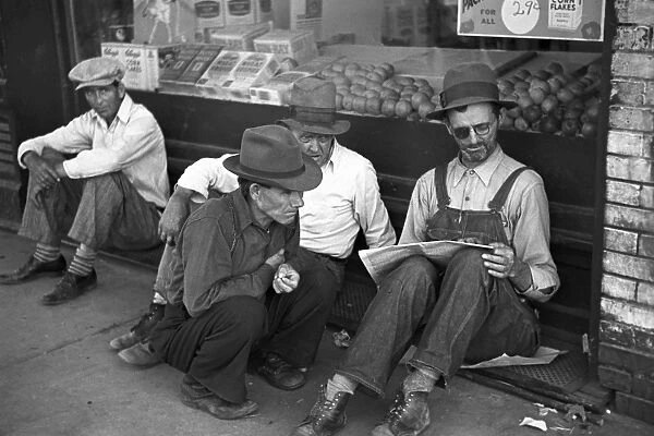 MISSOURI: FARMERS, 1936. Four farmers sitting on a grate in front of a grocery