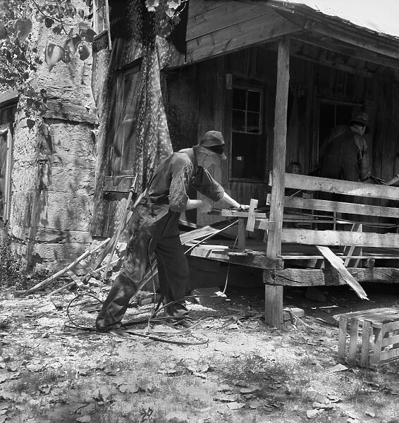 MISSOURI: SHARECROPPER. A sharecropper splitting hickory for chair-bottoms in the Ozark Mountains