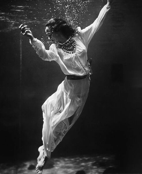 MODEL UNDERWATER, 1939. A fashion model underwater in a dolphin tank at Marineland, Florida
