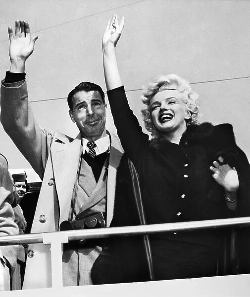 MONROE & DIMAGGIO, c1954. Marilyn Monroe and her husband Joe DiMaggio, waving to a crowd. Photograph, c1954
