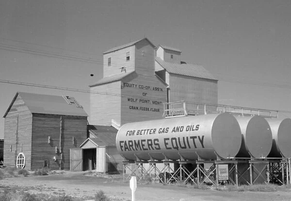 MONTANA: FARM, 1941. Grain elevators and oil tanks at a farm in Wolf Point, Montana