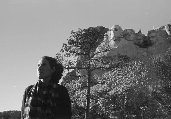 MOUNT RUSHMORE, c1936. A woman posing in front of the construction of Mount Rushmore