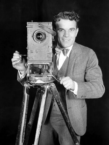 MOVIE CAMERA, 1920s. The actor Nick Stuart in a publicity still from the 1920s silent film The News Parade