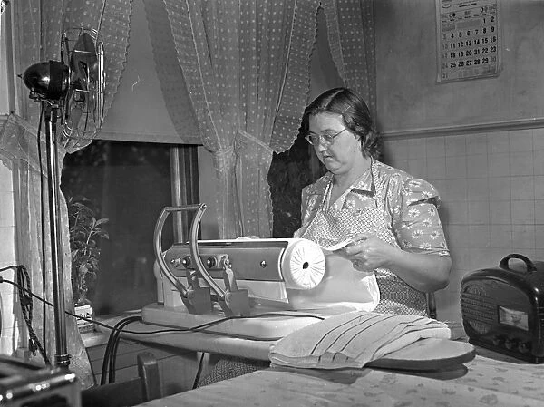 Mrs. Robert Bacon, a farm wife in Knox County, Tennessee, using electrical appliances in her home (a fan, an iron, and a radio) with power supplied by the Tennessee Valley Authority. Photographed by Arthur Rothstein, 1942