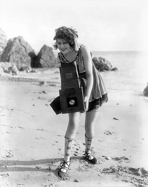 MYRTLE LIND (1901-1966). American actress, holding a Graflex camera on a beach, c1919