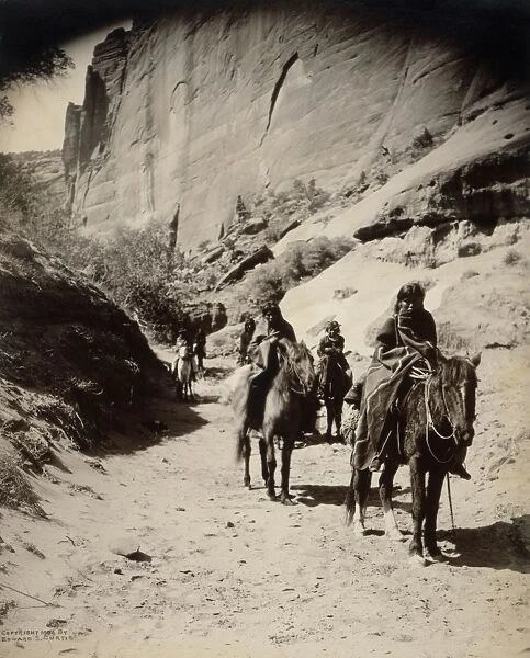 NAVAJOS, c1904. Group of Navajos on horseback, traveling through a canyon in the