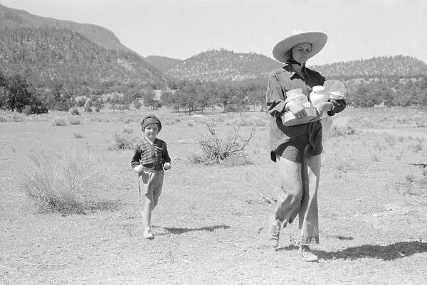 NEW MEXICO: HOMESTEADER. Mrs. Caudill and her daughter carrying household equipment