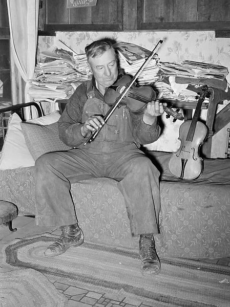 NEW MEXICO: MEN, 1940. George Hutton, a farmer from Maud, Oklahoma, playing his