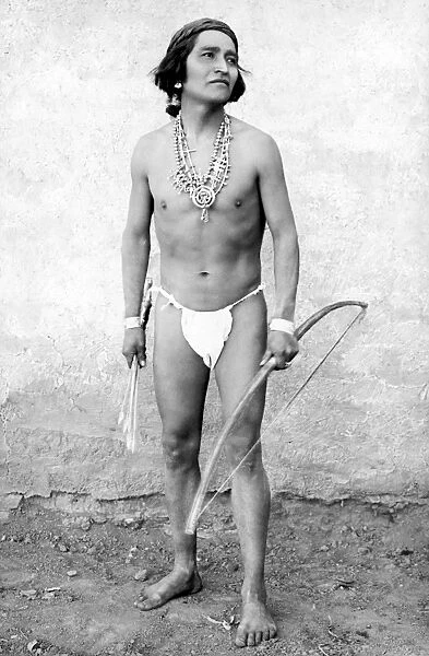 NEW MEXICO: ZUNI RUNNER. A Zuni runner holding a bow and arrow. Photograph, c1909