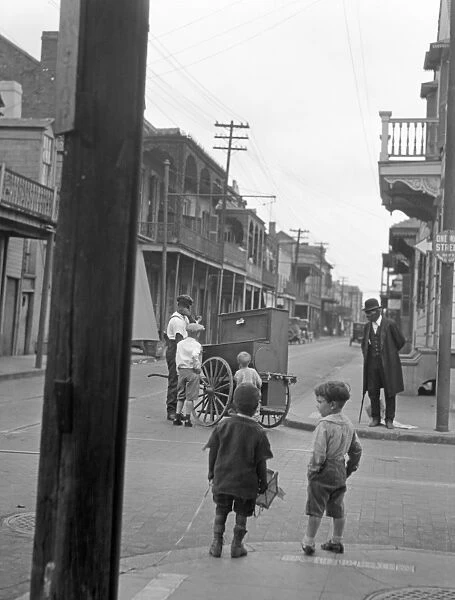 NEW ORLEANS, c1925. Children watching an organ grinder on the street corner in New Orleans