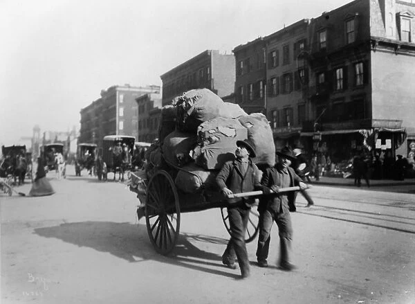 NEW YORK: CART, 1903. Two men pulling a loaded cart down 7th Avenue in Manhattan