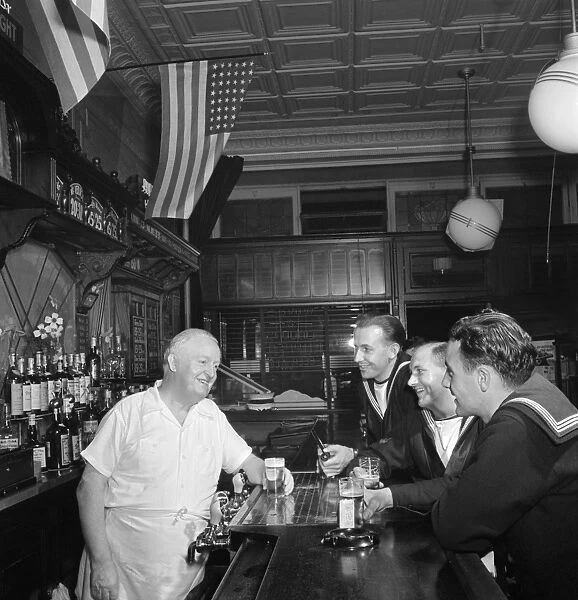 NEW YORK CITY: BAR, 1942. An Irish-American bartender serving beer to British sailors
