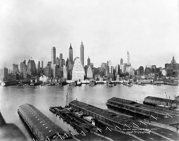 NEW YORK: EAST RIVER, c1931. The East River flows between Brooklyn piers and the Manhattan skyline