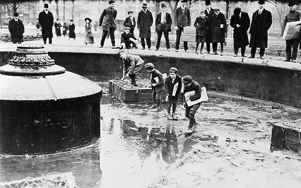 NEW YORK: FOUNTAIN, 1908. Four newsboys catching goldfish in a fountain at Union