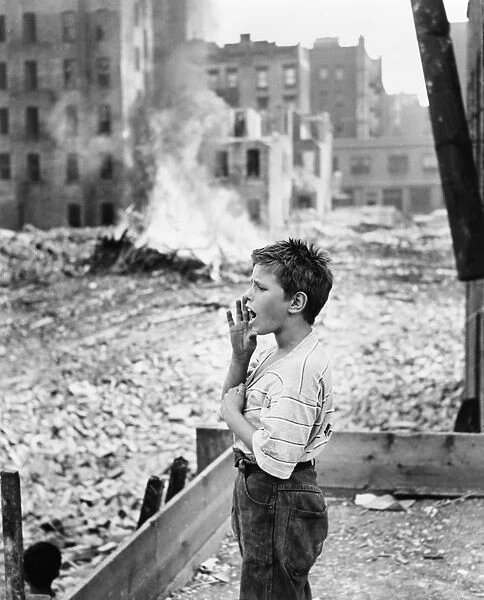 NEW YORK: SLUM, 1961. A boy yelling, backed by the remnants of a demolished slum