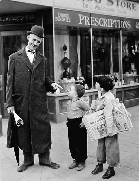 NEWSPAPER BOY, SILENT STILL. The comedian Charlie Chase with a newspaper boy in a still from an American silent movie of the 1920s