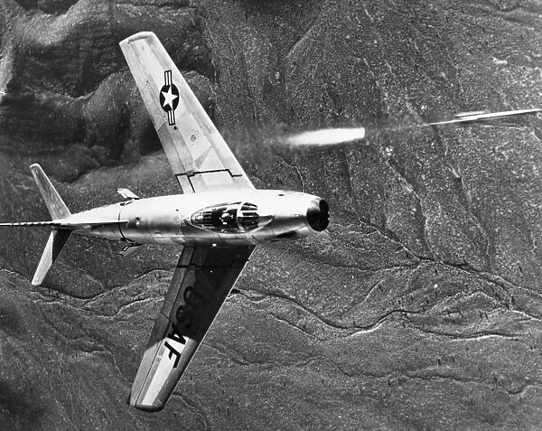 The North American F-86 Sabre combat aircraft releasing a rocket during training operations over the Nevada Desert Gunnery Range, 1951