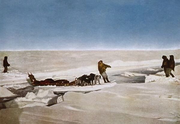 NORTH POLE: DOG SLED, c1910. Men and a dog sled crossing water on a piece of an
