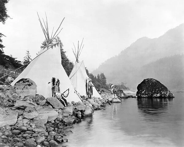 NORTHWEST INDIANS, 1922. Native Americans (probably Umatilla) stand beside tepees on the Columbia River. Photographed in 1922 by Ralph Irving Gifford