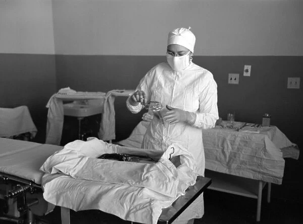 NURSE, 1942. A nurse prepares for an operation at the Cairns General Hospital in