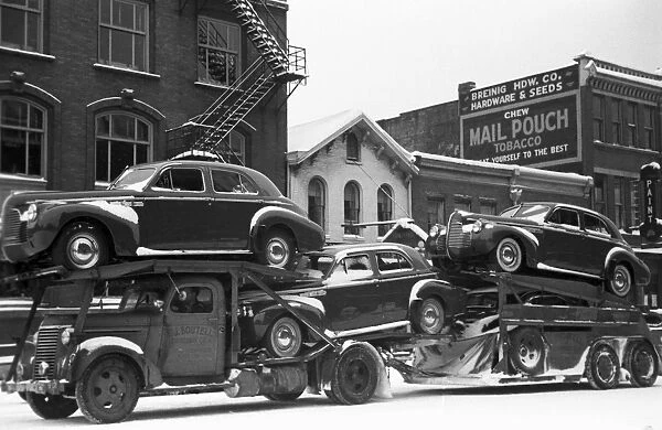 OHIO: AUTO TRANSPORT, 1940. A truck carrying automobiles through the streets of Chillicothe, Ohio. Photograph by Arthur Rothstein, February 1940