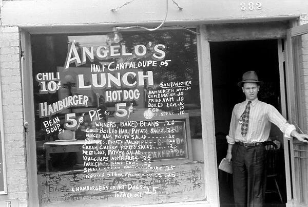 OHIO: COLUMBUS, 1938. Man stands in the entrance to a lunchroom in Columbus, Ohio
