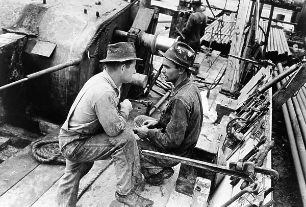 Oil field workers talking at an oil well in Kilgore, Texas. Photograph by Russell Lee, April 1939