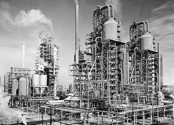 Three oil refinery units in Louisiania, which use the process of cracking, set up to supply fuel for allied units fighting in World War II. Photograph, c1944