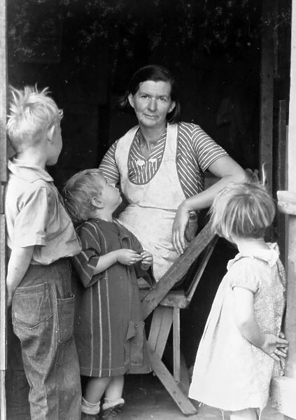 OKLAHOMA SQUATTERS, 1935. A woman with her children at the entrance to a squatter s