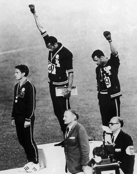 OLYMPIC GAMES, 1968. American runners Tommie Smith (center) and John Carlos (right) showing the Black Power salute during the medal ceremonies at the Olympic Games in Mexico City. Australian Peter Norman (left) wears an OPHR badge in solidarity. Photograph, 1968