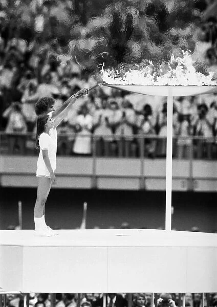 OLYMPIC GAMES, 1976. Torch bearers Sandra Henderson and Stephane Prefontaine lighting the Olympic flame at the opening ceremonies of the Summer Olympic Games in Montreal, Quebec, Canada, 17 July 1976