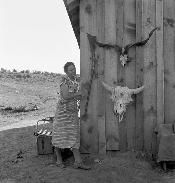 OREGON: FARM WIFE, 1939. A farmers wife standing beside two animal skulls