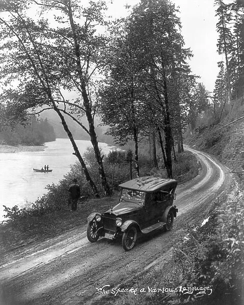 OREGON: ROAD, c1921. A car on a road beside a fishing stream in Oregon. Photograph