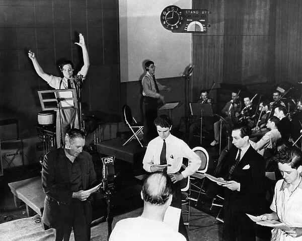 ORSON WELLES (1915-1985). American director, producer, screenwriter, and actor. Welles (left rear) directing a rehearsal of his radio adaptation of H. G. Wells novel The War of the Worlds, at CBS studios in New York City, October 1938