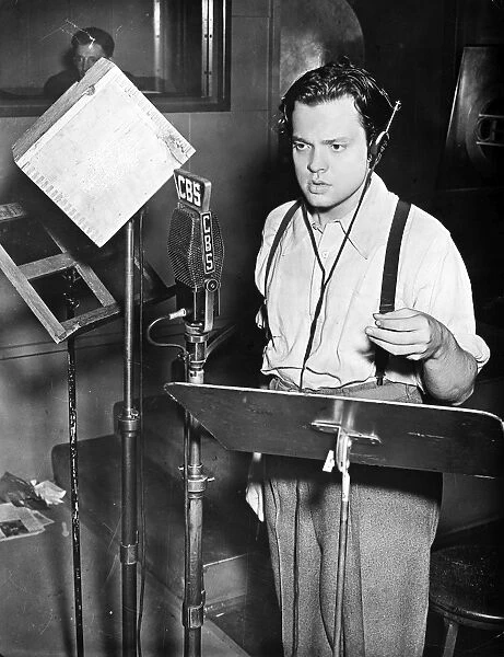 ORSON WELLES (1915-1985). American director, producer, screenwriter, and actor. Shown broadcasting his famous adaptation of H. G. Wells novel The War of the Worlds, 30 October 1938