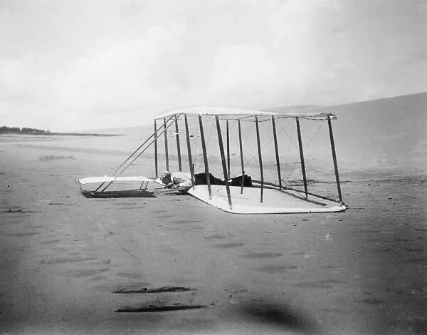 Orville Wright preparing for takeoff in the first Wright brothers biplane glider at Kitty Hawk, North Carolina. Photograph, 1901