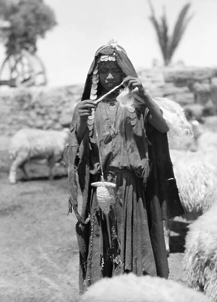PALESTINE: BEDOUIN WOMAN. A Bedouin shepherd spinning yarn, in the Sharon region of Palestine