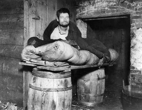 PEDDLERs BED, c1890. A peddler in his lodgings in the cellar of a Ludlow Street tenement