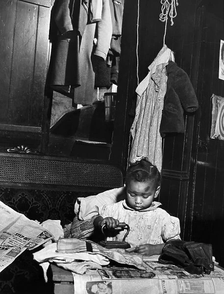 PENNSYLVANIA: SLUM, 1940. A child ironing at home in the slum area of New Brighton, Pennsylvania