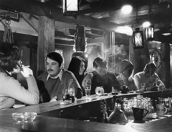 People smoking and drinking in a bar in Switzerland. Photograph, mid or late 20th century