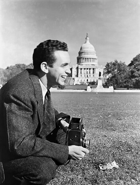 PHOTOGRAPHER, c1943. Photographer Howard Liberman, in front of the U. S. Capitol in Washington, D