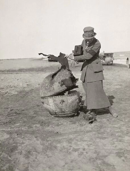 PHOTOJOURNALIST, 1919. Photojournalist Helen Jones Kirtland looking at a spent landmine
