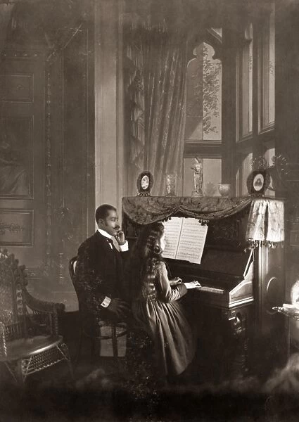 PIANO LESSON, c1900. An African American man giving a piano lesson to a young African
