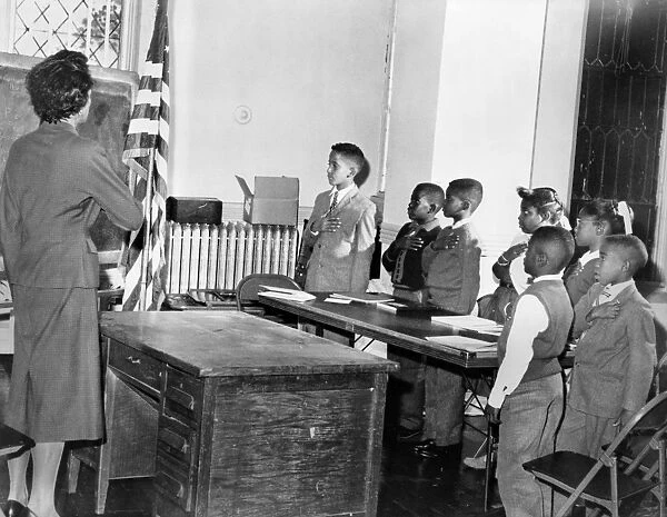PLEDGE OF ALLEGIANCE, 1958. Mrs. Claire Cumberbatch, a teacher at a school in the Bedford-Stuyvesant neighborhood of Brooklyn, New York, leads a class in the pledge of allegiance. Photograph by Dick DeMarisco, 1958