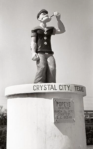 POPEYE MONUMENT, 1939. Statue of the comic strip character Popeye erected on 26 March 1937 in Crystal City, Texas which became known as the spinach capital of the world. Photograph by Russell Lee, March 1939